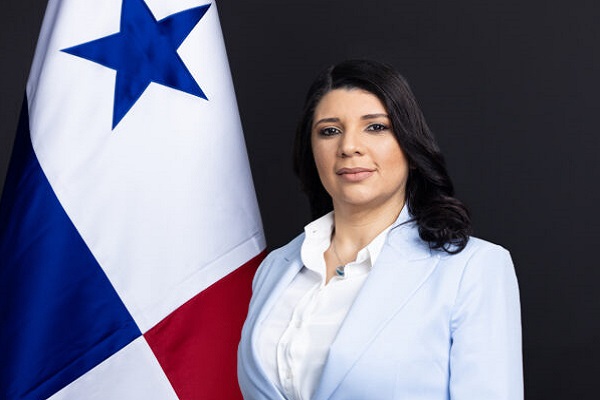 Ministra Jackeline Muñoz junto a bandera de Panamá.