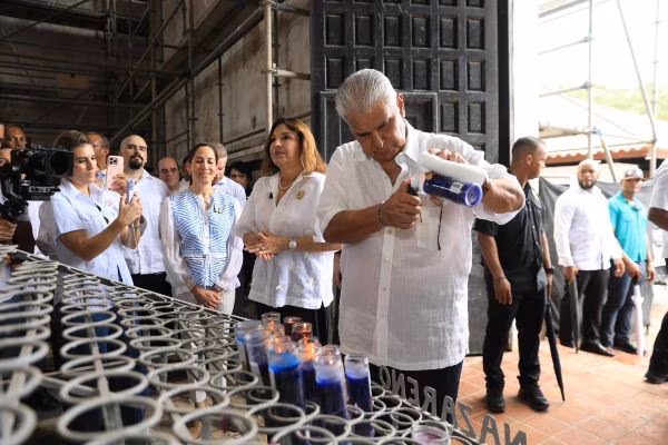 Presidente Mulino enciende una vela al cristo negro.